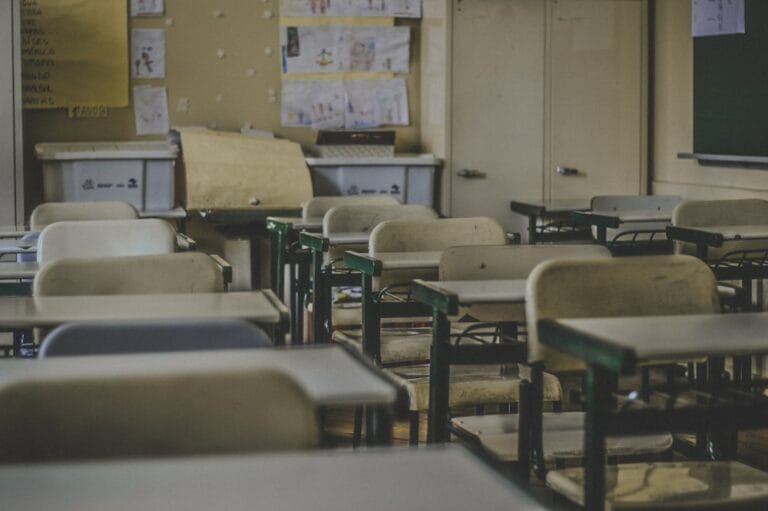Klassenzimmer: Tische, Stühle und leere Schulbänke für den Unterricht in der Schule.