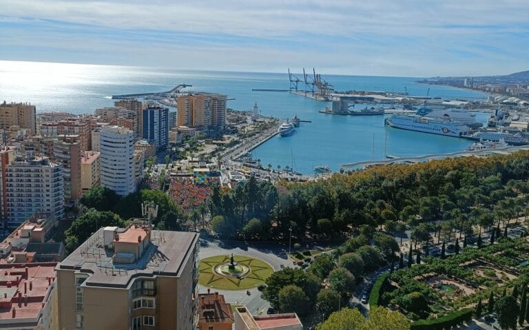Das Bild zeigt Wohnhaeuser und den Hafen von Malaga