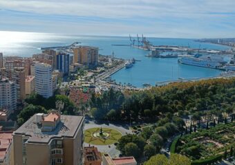 Das Bild zeigt Wohnhaeuser und den Hafen von Malaga