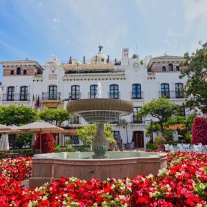 Foto von Estepona mit roten Blumen im vordergrund